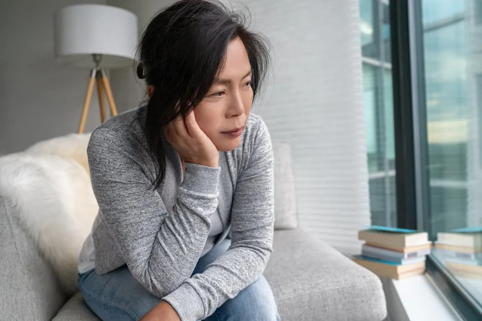 Sad woman sitting alone at home.