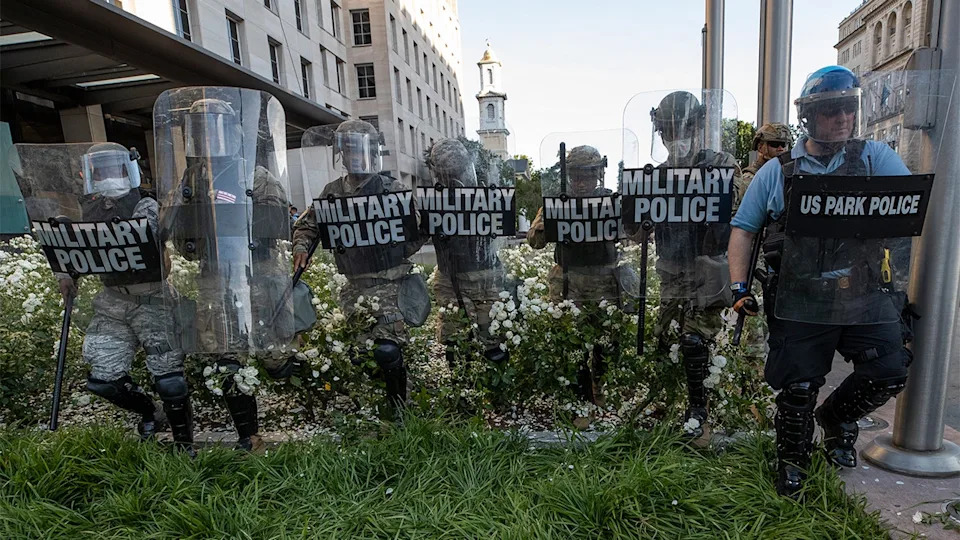 District of Columbia National Guard, and U.S. Park Police, advance through the white roses in front of the AFL-CIO headquarters, with St. John's Church behind them, as they move demonstrators back after they gathered to protest the death of George Floyd near the White House in Washington, June 1, 2020.