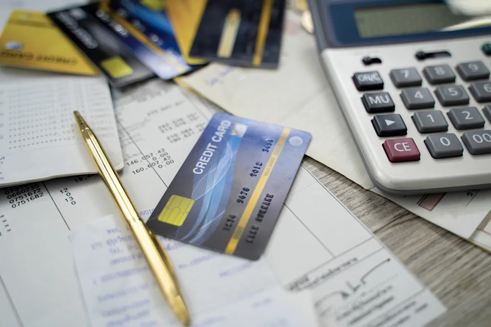 Calculator, credit cards, and receipts on a desk, suggesting financial planning or budgeting