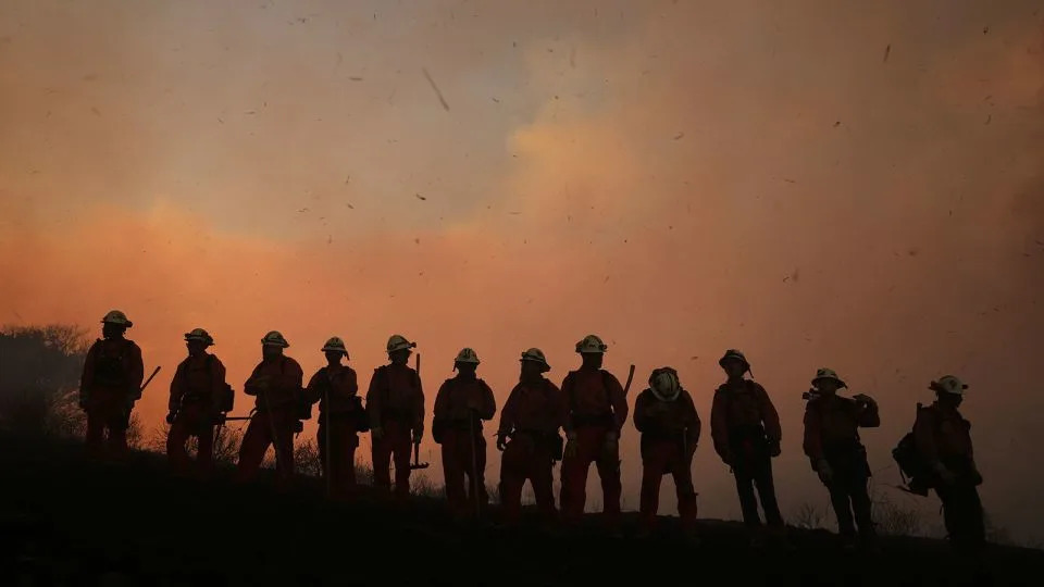 A California Department of Corrections fire crew looks on as the Canyon Fire burns on Thursday in Halsey Canyon, California. - Marcio Jose Sanchez/AP
