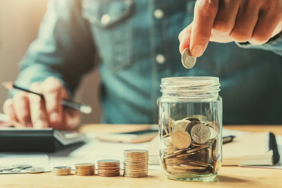 Man putting coins into savings.