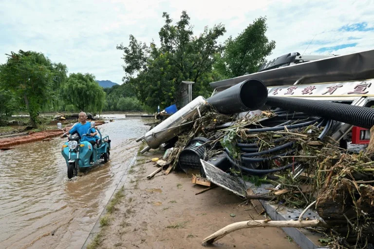 Swathes of northern China endured deadly rains and floods since last week that forced the evacuation of tens of thousands (ADEK BERRY)