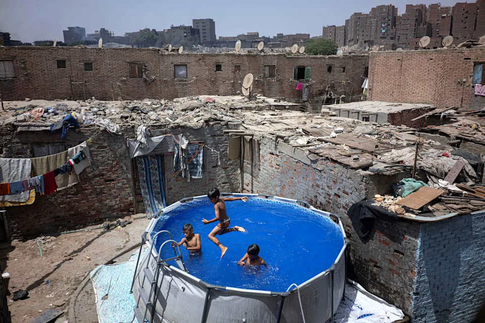 Several children play in a small swimming pool set up in a city in Egypt.