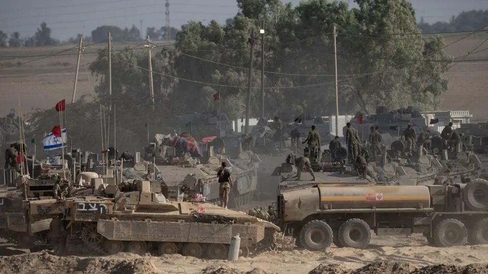 Israeli soldiers organize military equipment while standing on armored personnel carriers near the border with the Gaza, in southern Israel on Tuesday. - Amir Levy/Getty Images