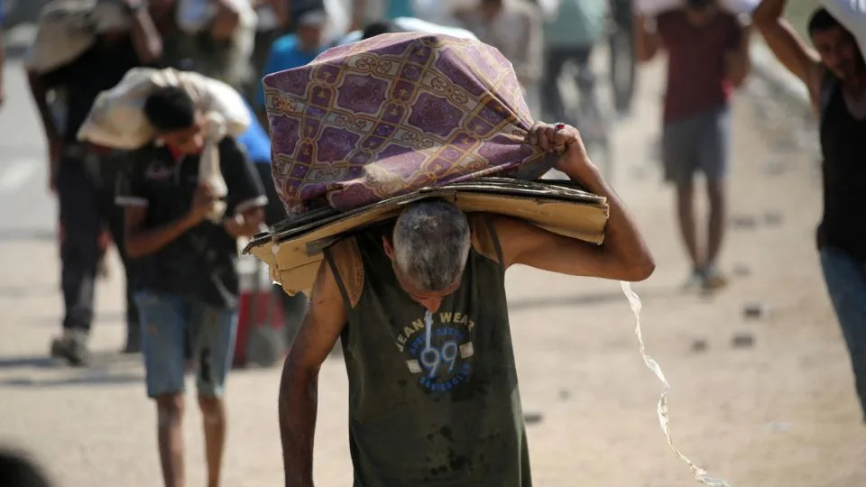 A man carries cardboard boxes as he returns from a food distribution site near the Netsarim corridor in the central Gaza Strip on August 3. - Eyad Baba/AFP/Getty Images