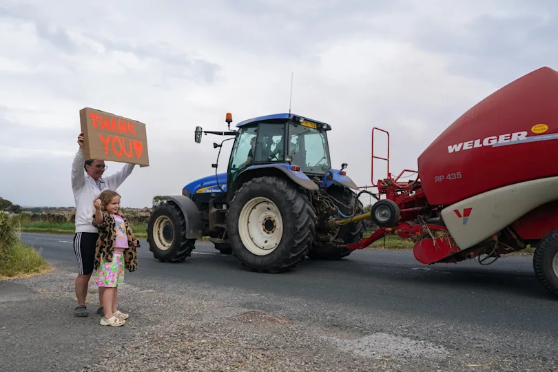 Verity McLeod, 7, and her mother Vicky hold a placard thanking local farmers as they pass on their way to assist with the firefighting efforts on Langdale Moor, where a wildfire had been burning for more than two weeks, Aug. 27, 2025, in Fylingdales, England. / Credit: Ian Forsyth/Getty