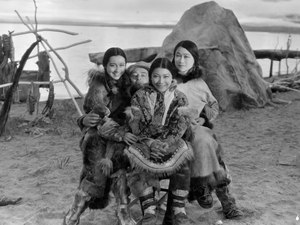 A group of four native Alaskans smiling for a group photograph in Alaska, 1955