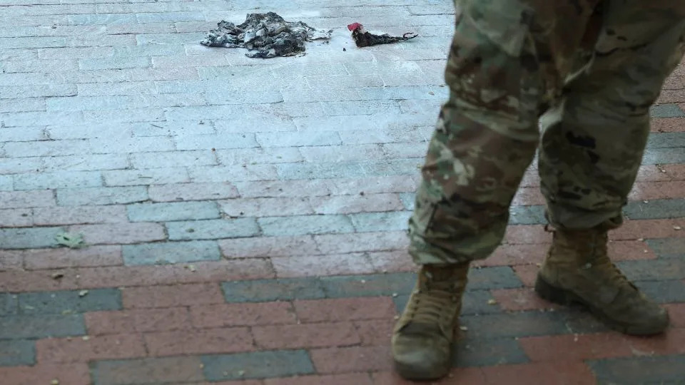 Army National Guard soldiers stand at the scene where a man burned a US flag on Monday. - Jonathan Ernst/Reuters