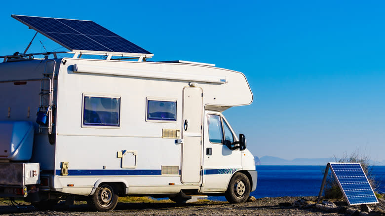 Multiple solar panels are mounted on the roof of an RV