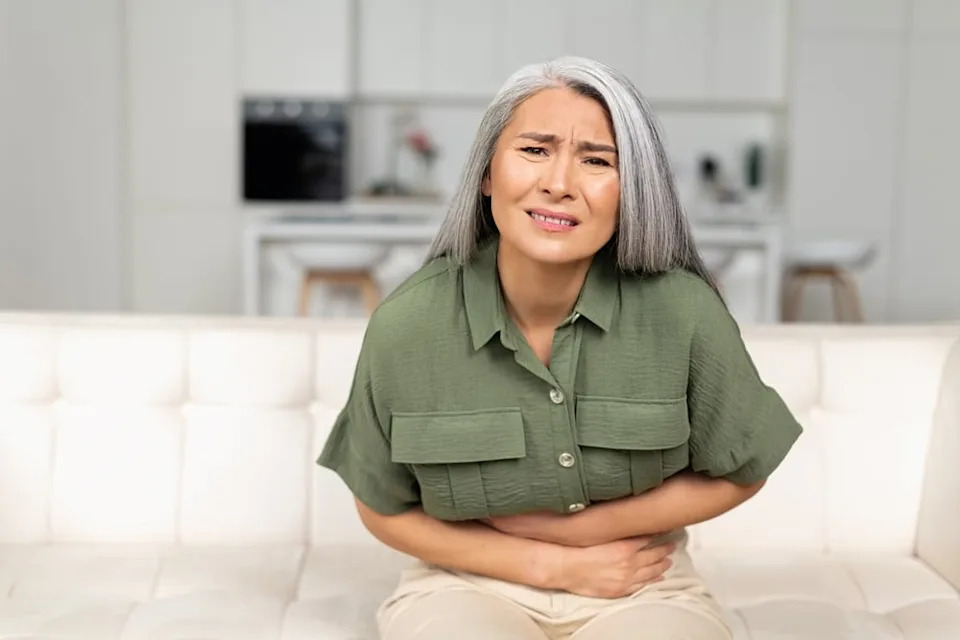 Woman holding her stomach in pain.