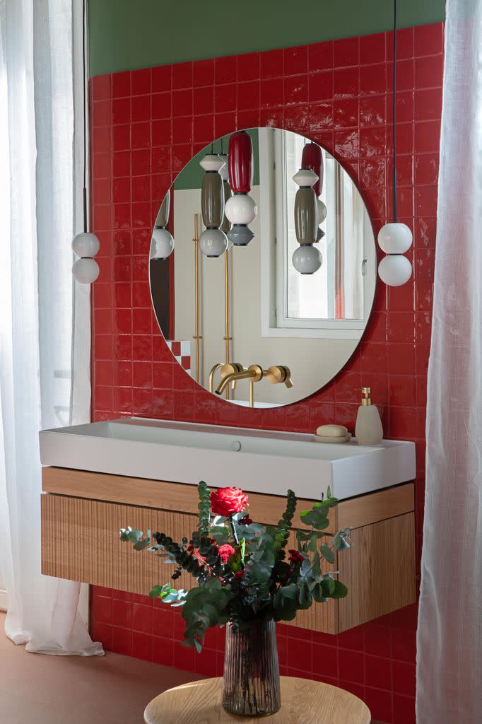 Baño con pared de azulejos rojos