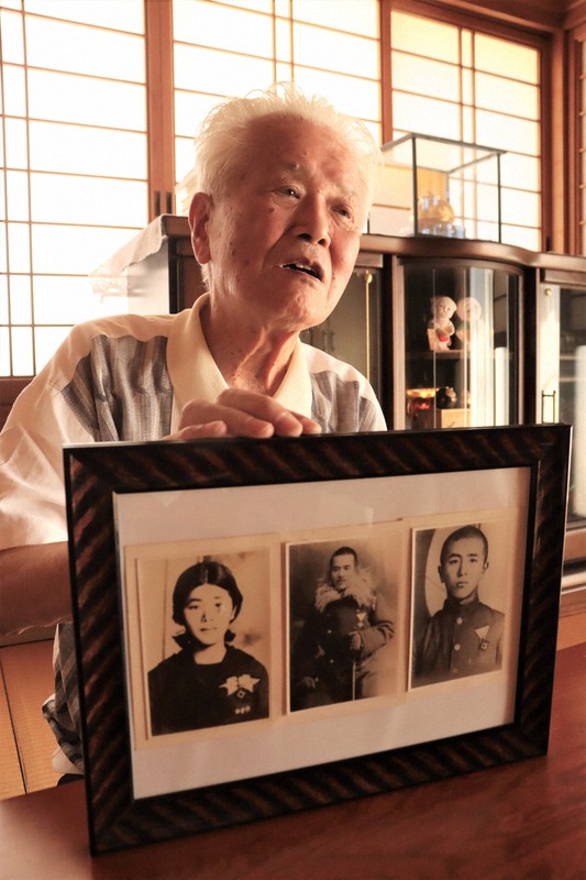 亡くなった父と兄、姉の遺影を手に、被爆体験を語る木下俊夫さん＝山口県山陽小野田市で2025年7月29日午後2時35分、井村陸撮影