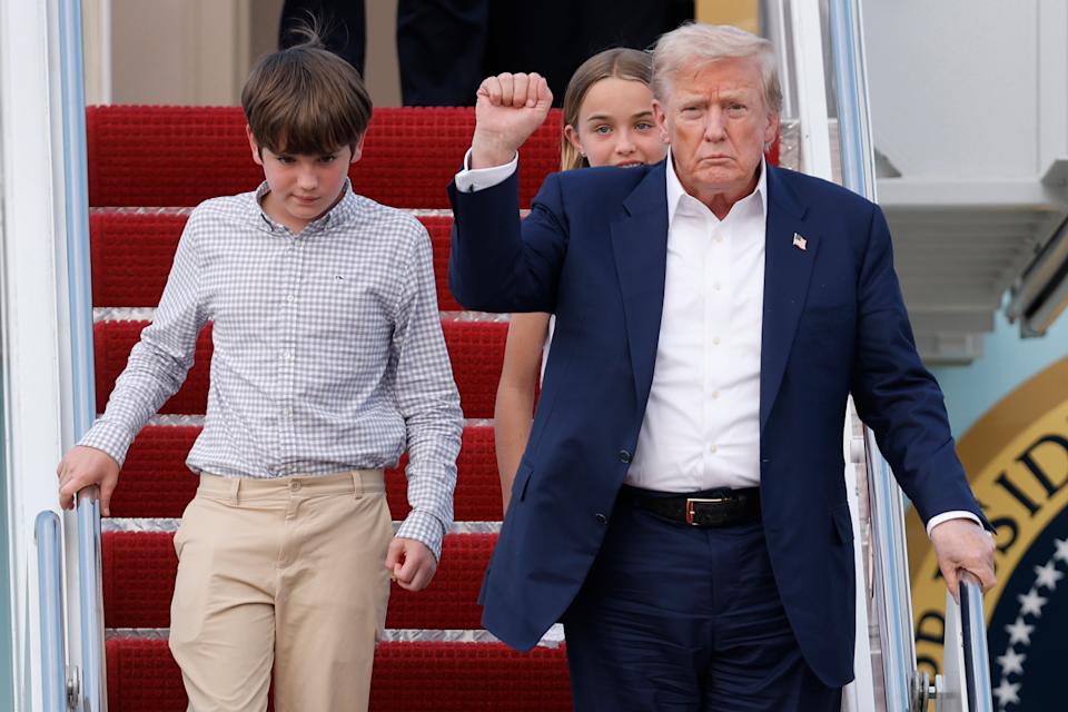 El presidente de Estados Unidos, Donald Trump, gesticula al bajar del Air Force One con sus nietos, Spencer y Chloe, a su llegada a la Base Conjunta Andrews, en Maryland, el 29 de julio de 2025. (AP Foto/Luis M. Alvarez)