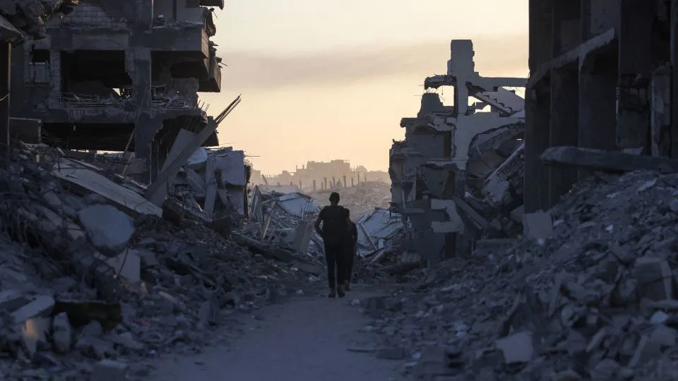 Men walk between piles of rubble in Saftawi neighbourhood, west of Jabalia in the northern Gaza Strip, on August 24, 2025. - Bashar Taleb/AFP/Getty Images
