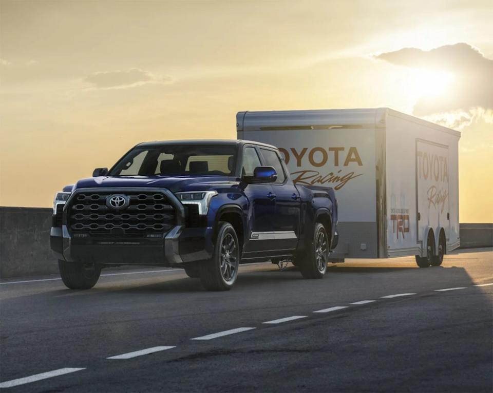 a photo of a blue toyota tundra towing a trailer