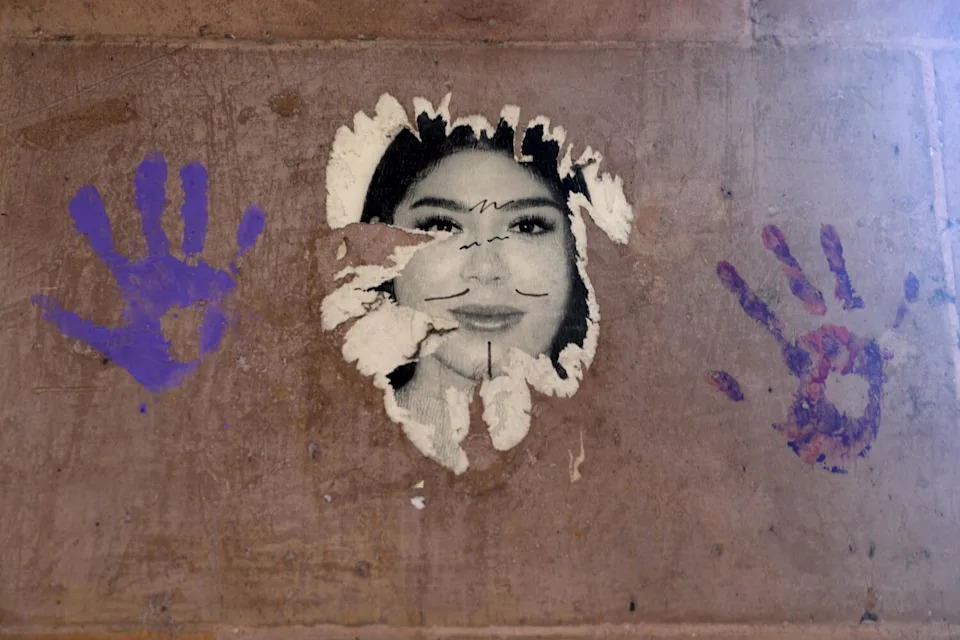 Handprints on a board flank a photo of a woman.
