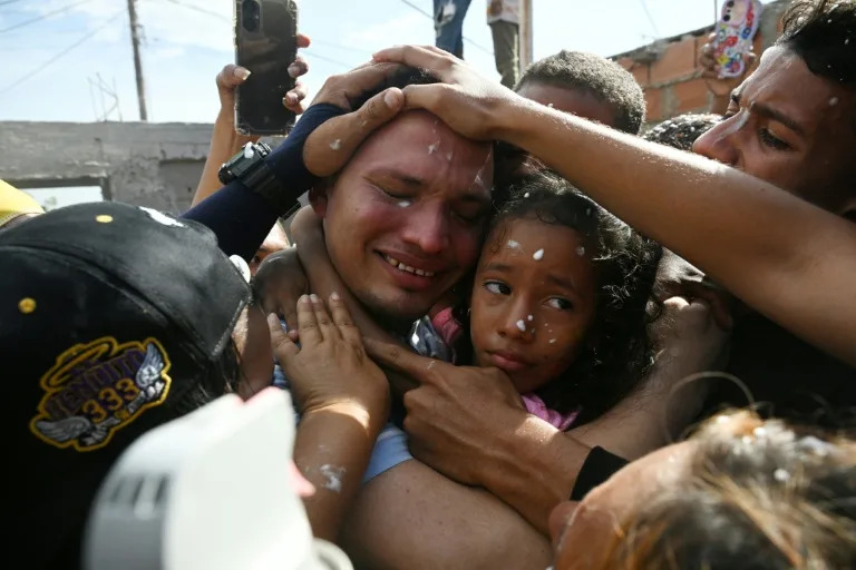 Mervin Yamarte (C), a Venezuelan migrant repatriated from a prison in El Salvador, is welcomed by his family upon arrival at his home in Maracaibo, Venezuela (Federico PARRA)
