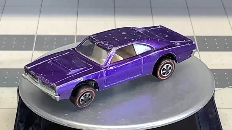 An old reddish-brown custom Dodge Charger Hot Wheels car with a white interior.