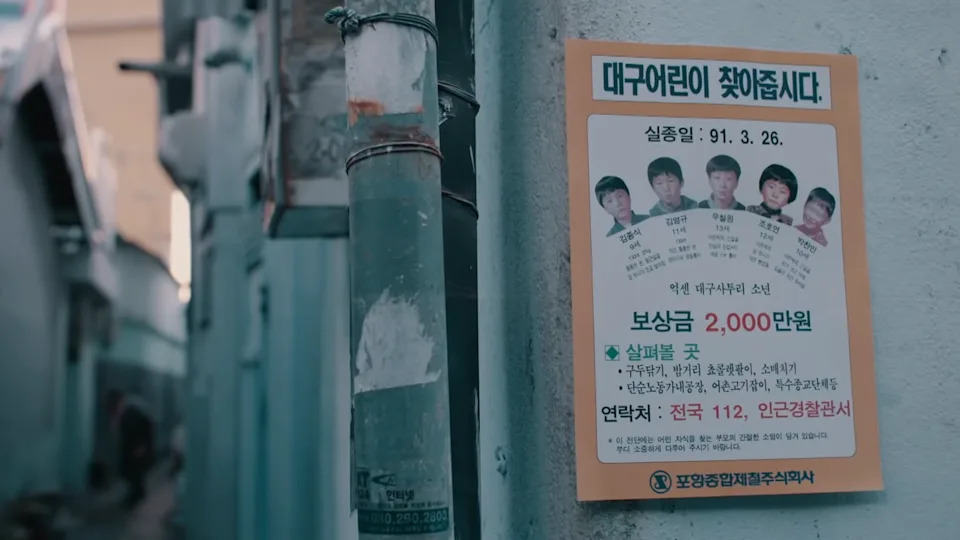 A missing person sign with images of the 5 boys posted on a wall