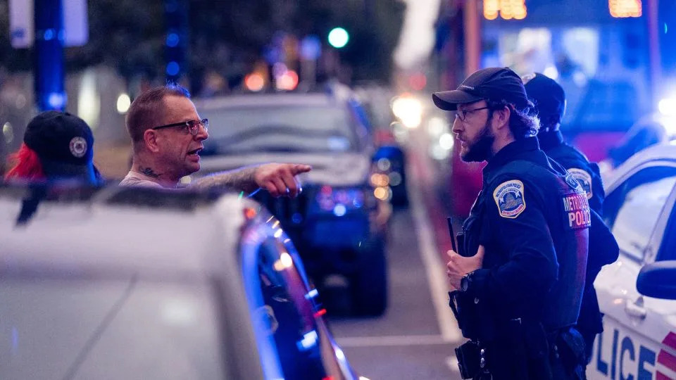 A protester argues with Metropolitan Police Department officers as they detain a man on H Street corridor on Wednesday. - Eric Lee for CNN