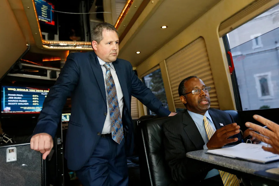 Republican Dr. Ben Carson talks with Iowa State Director Ryan Rhodes (left) and Director of Advance Mike Nason Tuesday, May 5, 2015 as he rides his campaign bus between stops in Cedar Rapids, Iowa.