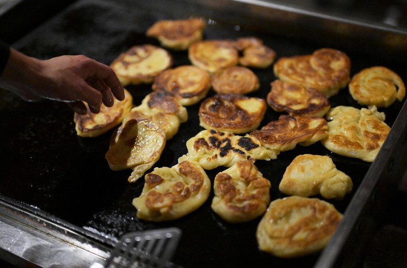 鉄板の上で揚げ焼きにされるバンパロタ＝京都市左京区で2025年5月17日、山崎一輝撮影