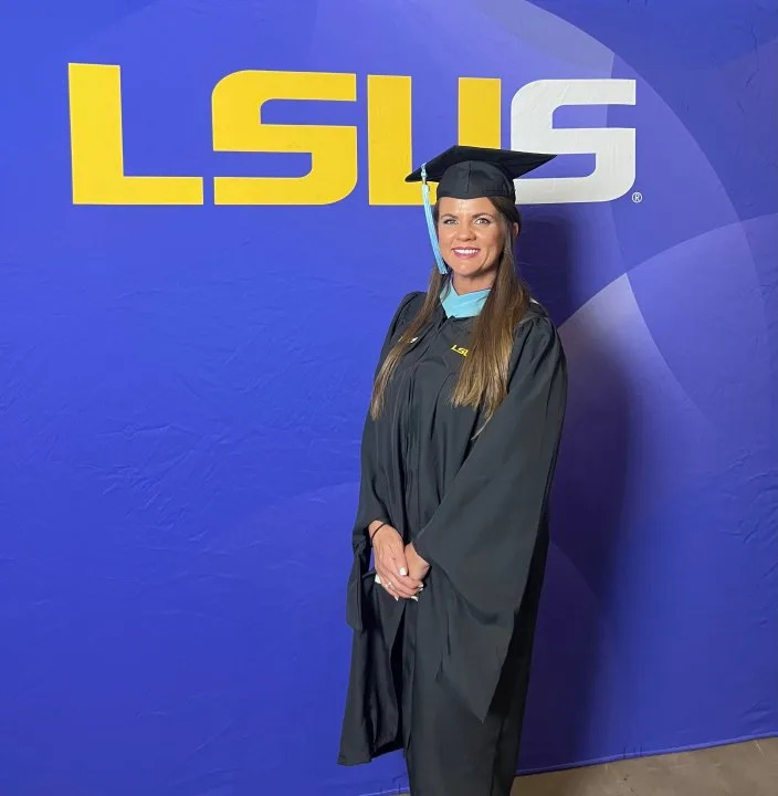 Graduation picture of Regena Hartley Beard in front of an LSUS logo.