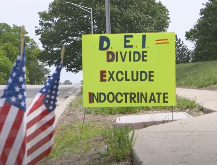 At a May 10 protest in Shawnee of school district practices, anti-DEI signs line the curb. (Screen grab of Darrin Dressler video)