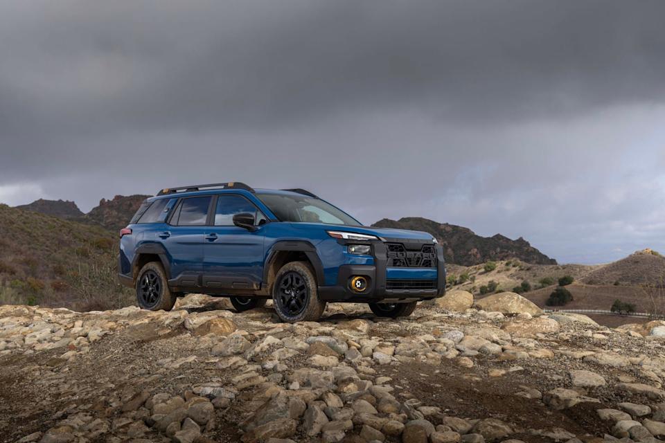 blue 2026 subaru outback wilderness front three quarter angle parked on a hill with mountains behind