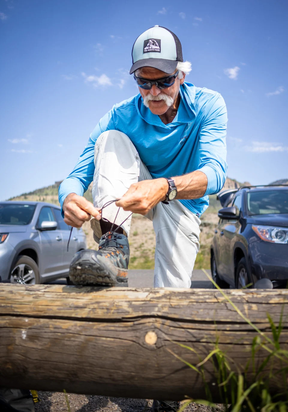 Doug Smith, who headed up the wolf project at Yellowstone National Park for nearly 30 years ties his shoelaces before setting out on the trail to scout for wolves on July 10, 2024, at Yellowstone National Park. (Photo by Pat Sutphin for the Idaho Capital Sun)