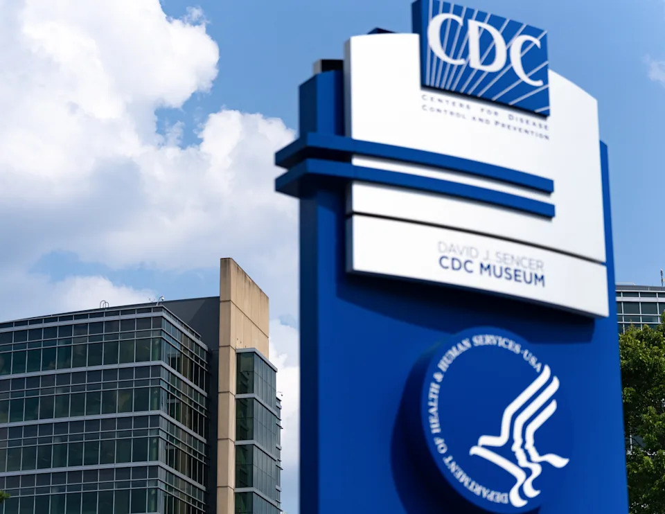 Sign for the CDC's David J. Sencer Museum with modern buildings in the background