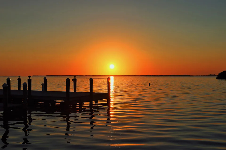 The setting sun hovers above the horizon off the Pine Island coastline. Taken with a Canon Rebel T5i at f/11, ISO=100 and 1/320 sec.