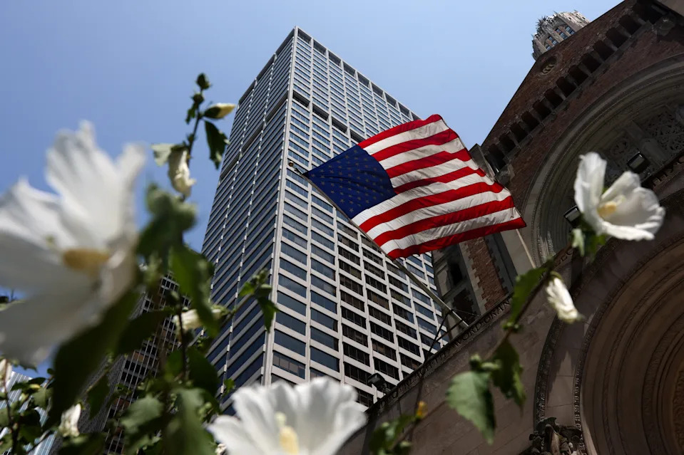 A U.S. flag flies outside the building where a deadly mass shooting occurred on Monday at the building housing the NFL's league offices in Manhattan.
