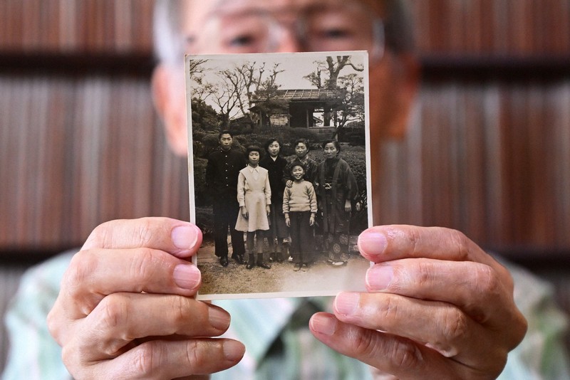 昭和30年ごろに撮影されたとみられる家族写真を手にする松田勝三さん＝長崎市で2025年6月30日、北山夏帆撮影