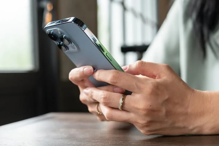 Hands of a woman using iPhone.