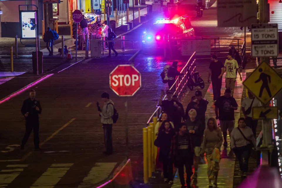 A police officer drives at Santa Monica Pier while warning the public about the regular closure time of the pier amid a tsunami warning (AFP via Getty Images)