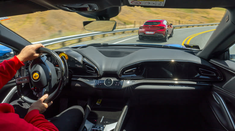 the view from the back seat of a Purosangue chasing a red Purosangue on a twisty road