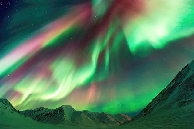 Getty Strong geomagnetic activity illuminates the Alaskan skies with a mesmerizing display of the Aurora Borealis (Northern Lights), gracefully pirouetting above the mountain peaks near Atigun Pass - Dalton Highway, situated to the north of Fairbanks, Alaska, USA