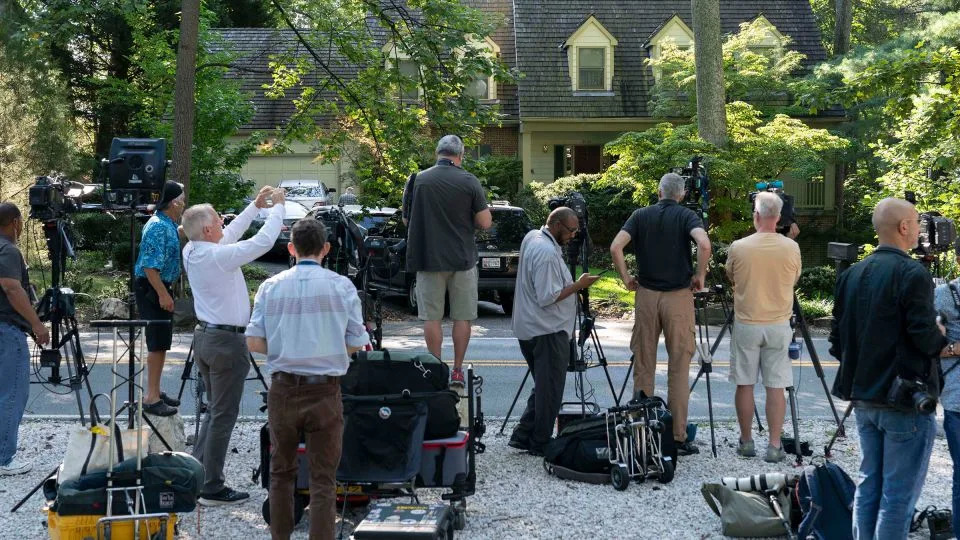 Media watch outside former national security adviser John Bolton's house as FBI agents search inside. - Jose Luis Magana/AP
