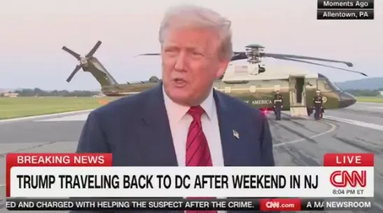A man speaks to the media near a helicopter on a tarmac. News ticker: "Trump traveling back to DC after weekend in NJ."