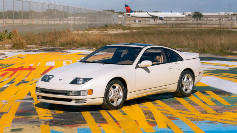a white 1993 300ZX twin turbo parked on painted asphalt in front of a Delta jet