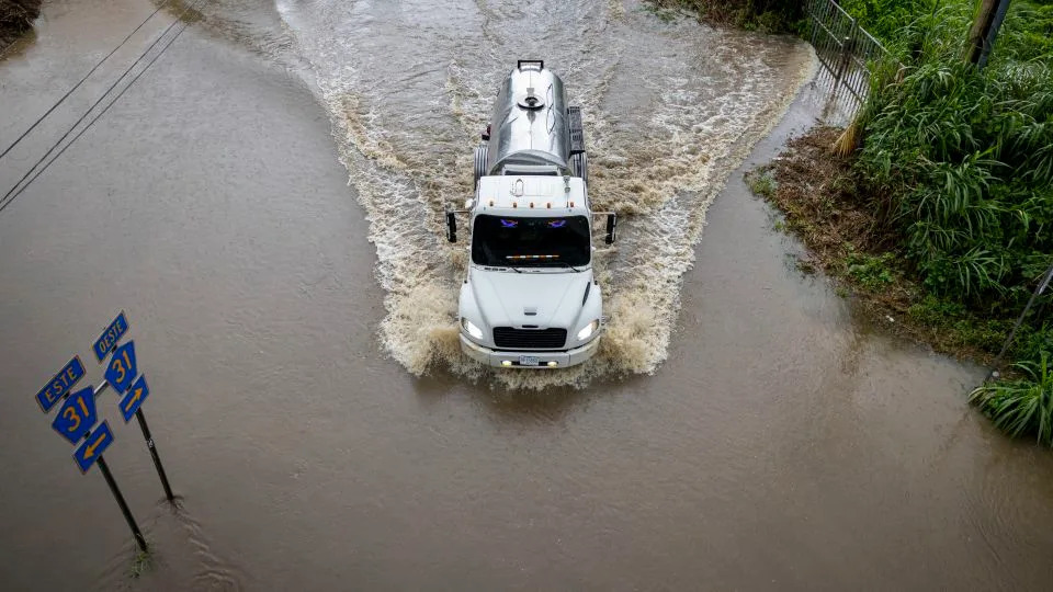 A truck drives through a flooded road as Category 3 Hurricane Erin leaves the region in Naguabo, Puerto Rico, on August 16, 2025. - Ricardo Arduengo/AFP/Getty Images