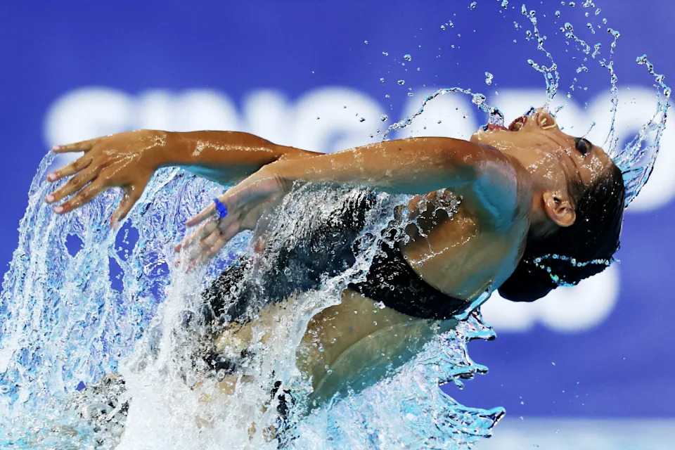 A swimmer crashes through the water during a performance.