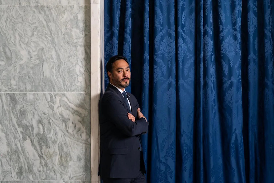 Rep. Joaquin Castro leans against a wall with arms folded