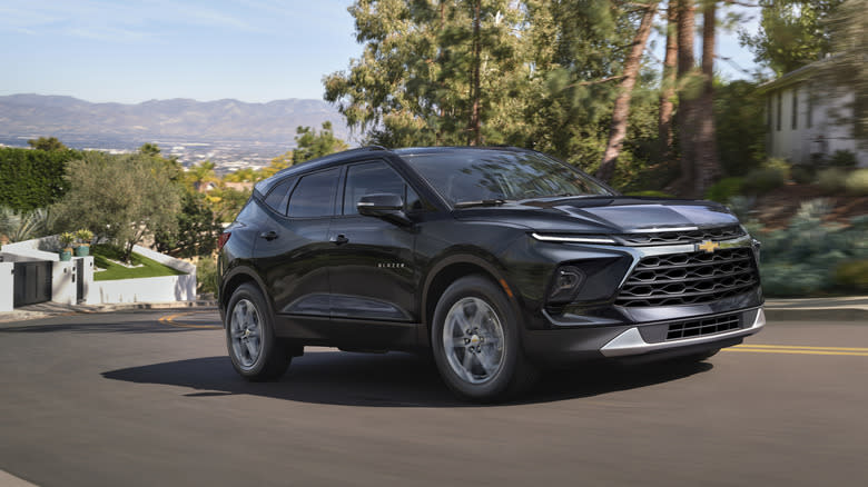 a gray 2025 Blazer driving on a hill in a neighborhood