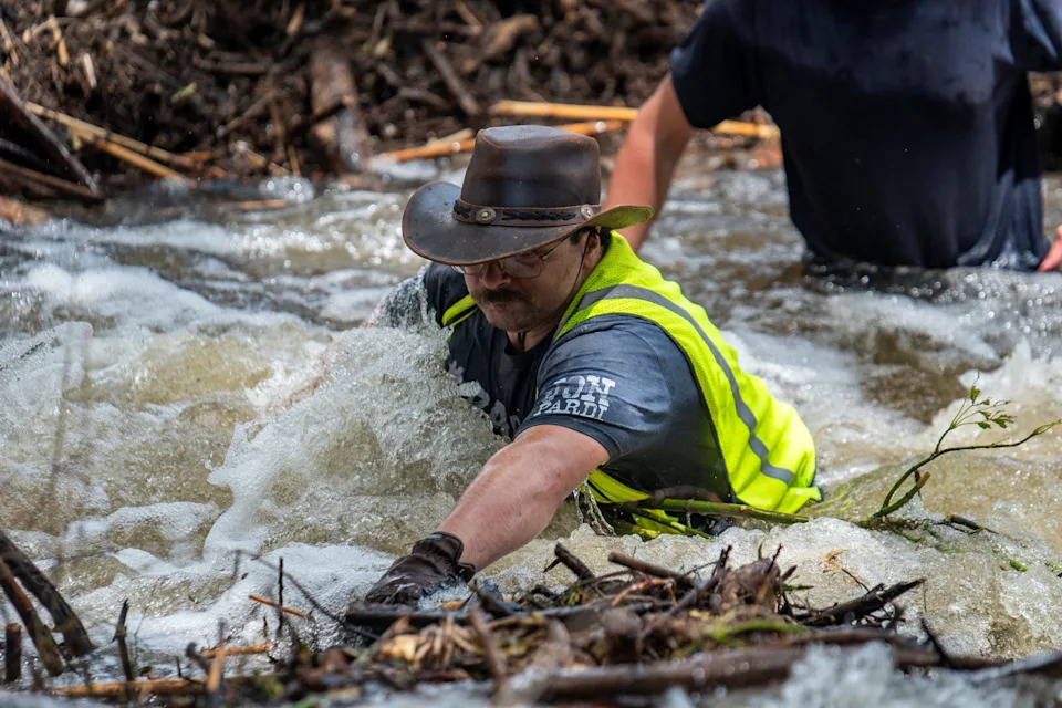 Brandon Myrtle stands in the Guadalupe River as he tries to clear debris after catastrophic floods in Center Point, Texas, on July 11.