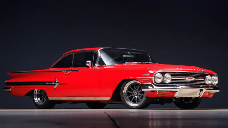 A red 1960 Impala coupe shot in a studio