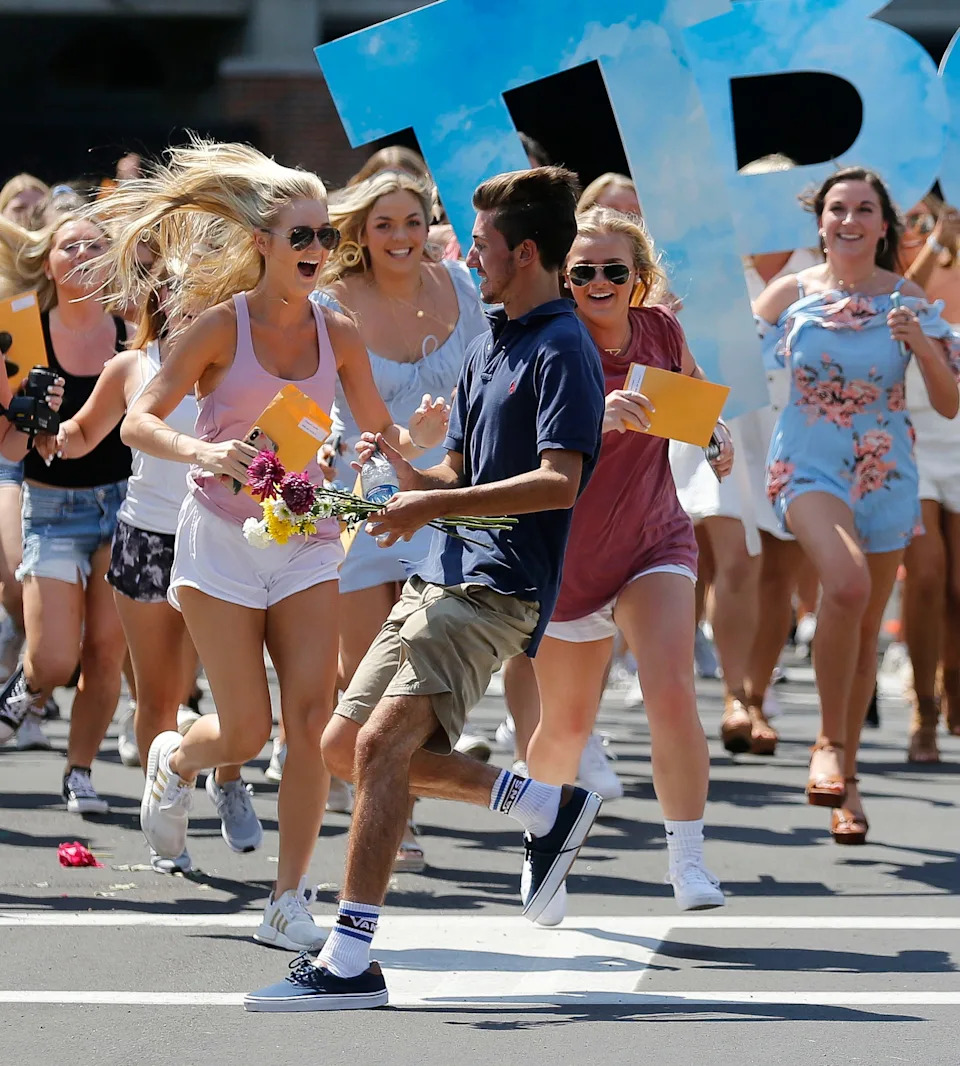 New Pi Beta Phi sorority members almost overrun a guy crossing the street as they run to their house during Sorority Bid Day outside Bryant-Denny Stadium Sunday, Aug. 18, 2019. The new members gathered in the stadium where they received their bids then ran in groups to the various sorority houses where they were met and greeted by sisters of each house. [Staff Photo/Gary Cosby Jr.]
