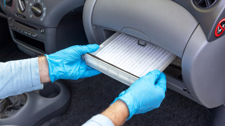 A mechanic checking cabin air filter