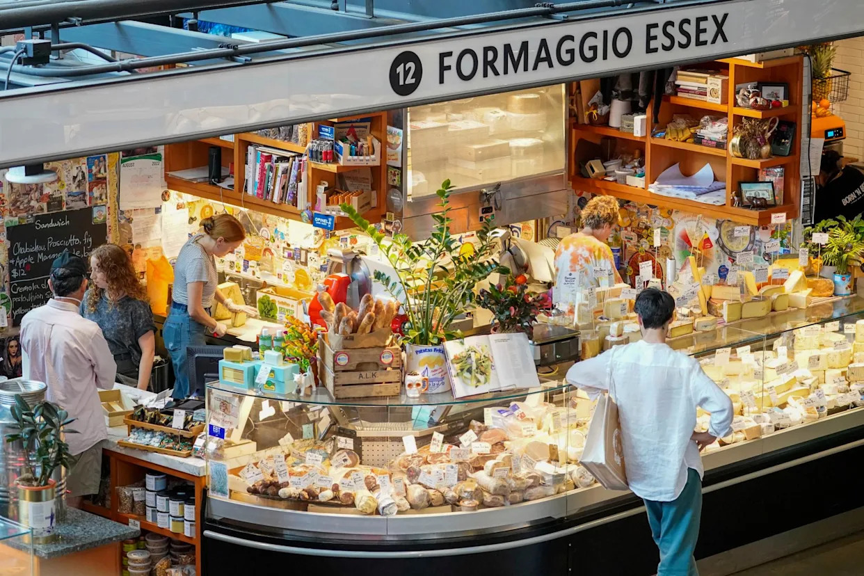 <span>Customers shop at a cheese shop at the Essex Market, a public grocery store, on the Lower East Side of Manhattan in 2022.</span><span>Photograph: Mary Altaffer/AP</span>